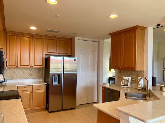 kitchen featuring appliances with stainless steel finishes, sink, backsplash, kitchen peninsula, and light tile patterned flooring