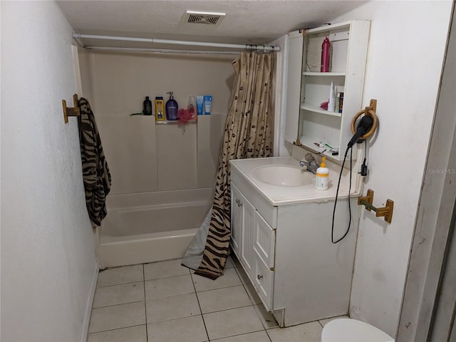 full bathroom featuring vanity, tile patterned floors, shower / tub combo, toilet, and a textured ceiling