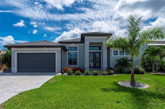 prairie-style house with french doors, a front lawn, and a garage