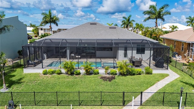 rear view of house featuring a lawn, glass enclosure, and a fenced in pool