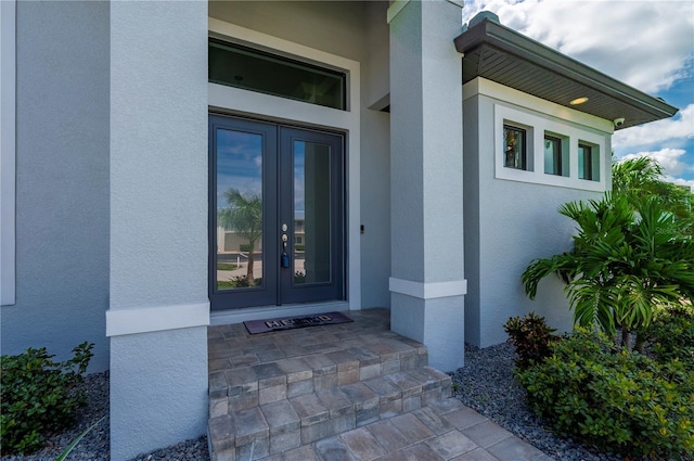 view of exterior entry with covered porch and french doors