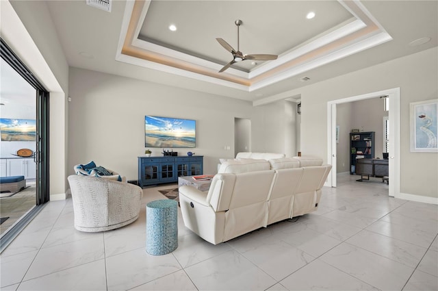 living room with a tray ceiling, ceiling fan, and crown molding