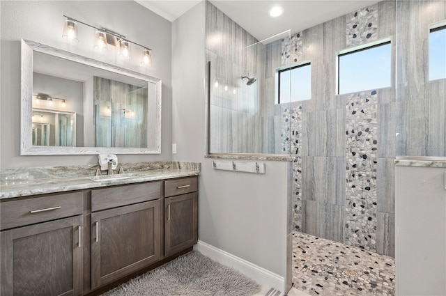 bathroom featuring a tile shower and vanity