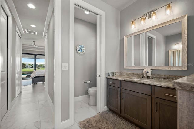 bathroom featuring vanity, ceiling fan, toilet, and ornamental molding