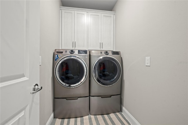 laundry room featuring cabinets and separate washer and dryer