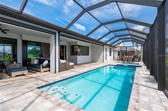 view of pool with outdoor lounge area, a patio area, ceiling fan, and glass enclosure