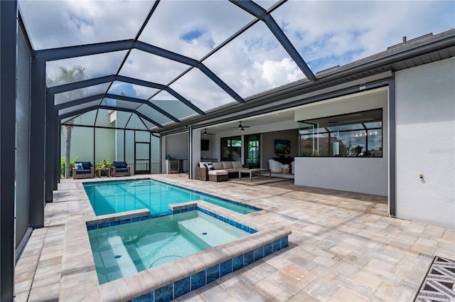 view of swimming pool with outdoor lounge area, glass enclosure, ceiling fan, an in ground hot tub, and a patio area