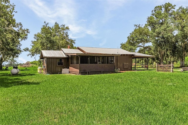 back of property with an outdoor structure and a yard