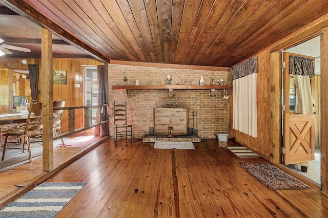 unfurnished living room with brick wall, wooden ceiling, and hardwood / wood-style flooring