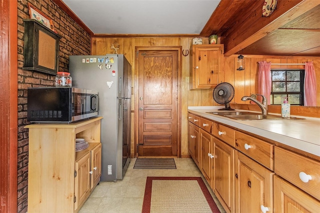 kitchen featuring beamed ceiling, stainless steel appliances, wooden walls, and light tile flooring