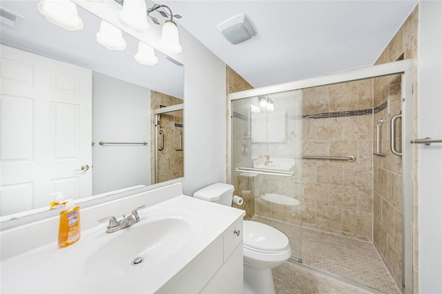 bathroom with vanity, a shower with shower door, and toilet