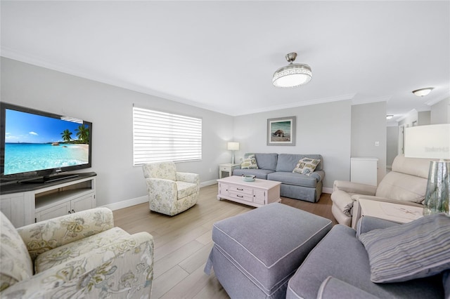 living room with ornamental molding and light hardwood / wood-style flooring