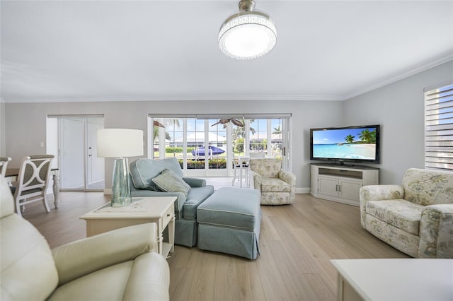 living room featuring light hardwood / wood-style flooring, plenty of natural light, and crown molding