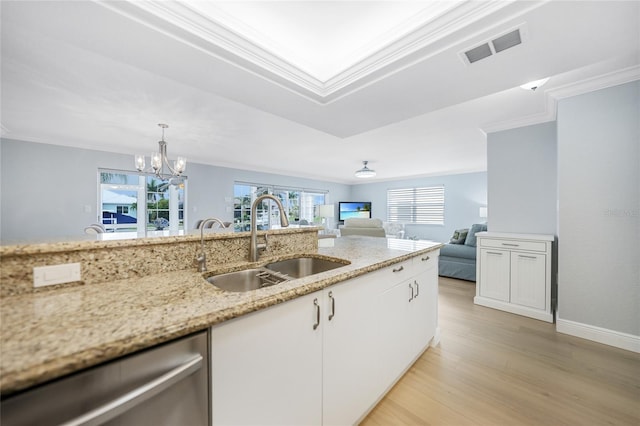 kitchen featuring dishwasher, sink, an inviting chandelier, light stone counters, and white cabinets