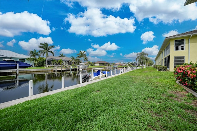 view of dock featuring a lawn and a water view