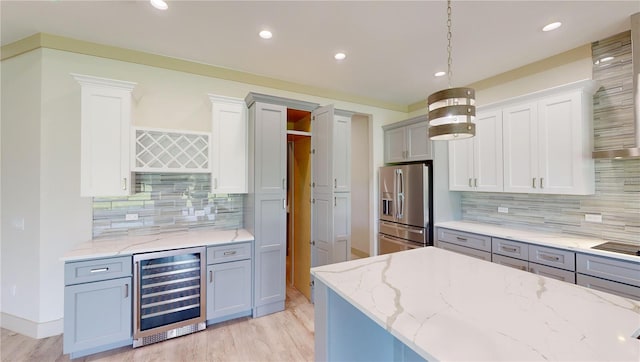 kitchen featuring stainless steel fridge with ice dispenser, gray cabinets, beverage cooler, pendant lighting, and light stone counters