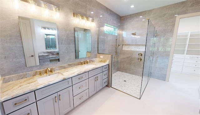 bathroom featuring tile walls, a shower with shower door, and vanity