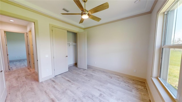 unfurnished bedroom featuring ceiling fan, crown molding, and light hardwood / wood-style floors