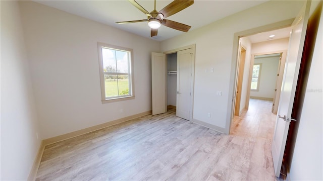 unfurnished bedroom featuring light wood-type flooring, ceiling fan, and a closet