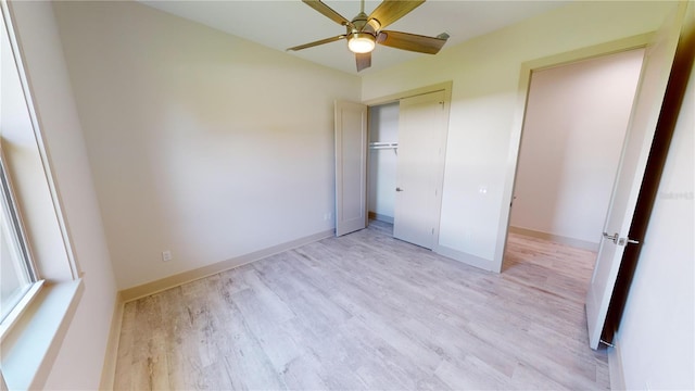 unfurnished bedroom with light wood-type flooring, ceiling fan, and a closet