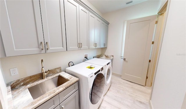 laundry area featuring cabinets, sink, and washing machine and dryer