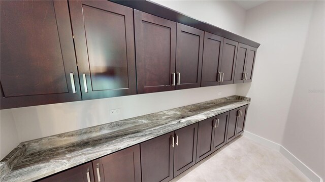 interior space featuring light stone counters and dark brown cabinetry