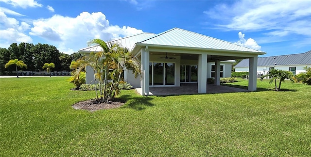 back of property featuring ceiling fan, a yard, and a patio