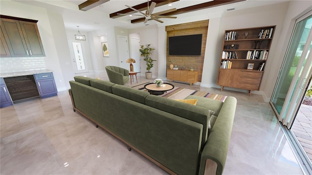 living room with beam ceiling and ceiling fan with notable chandelier