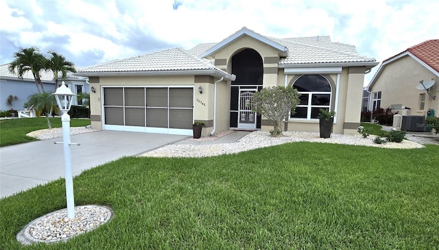 view of front of house featuring a garage, central air condition unit, and a front lawn