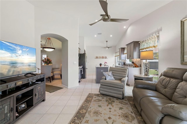 living room featuring ceiling fan, sink, light tile patterned floors, and high vaulted ceiling