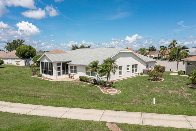 single story home featuring a front yard, central AC, and a sunroom