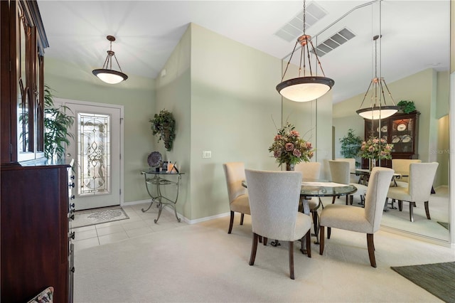 carpeted dining area with lofted ceiling