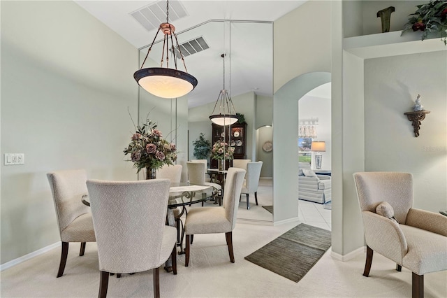 carpeted dining space featuring high vaulted ceiling