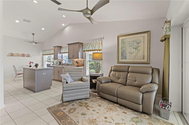 living room featuring ceiling fan, sink, light tile patterned floors, and vaulted ceiling