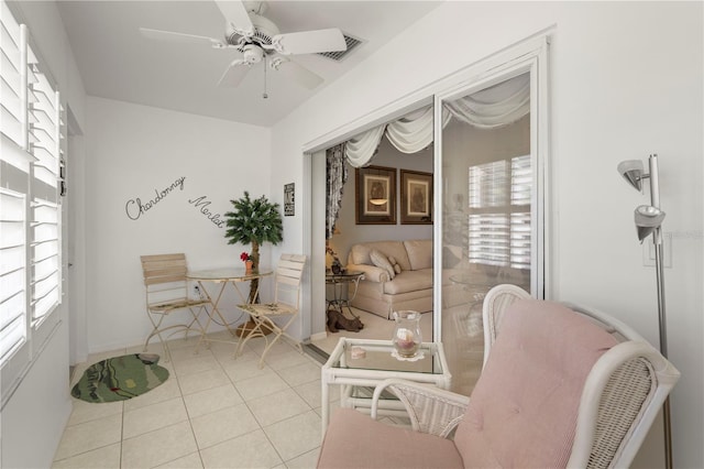 living area with ceiling fan and light tile patterned floors