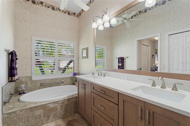 bathroom featuring vanity, a wealth of natural light, and tiled tub