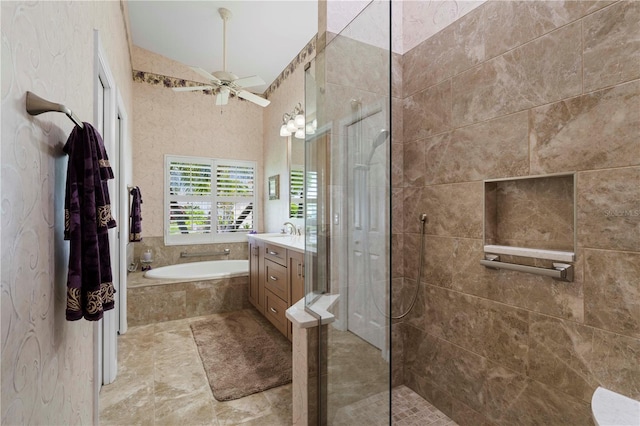 bathroom with shower with separate bathtub, vanity, ceiling fan, and lofted ceiling