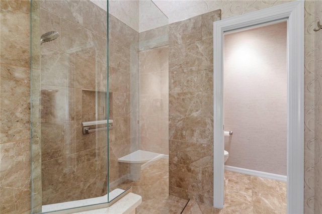 bathroom featuring a tile shower and toilet