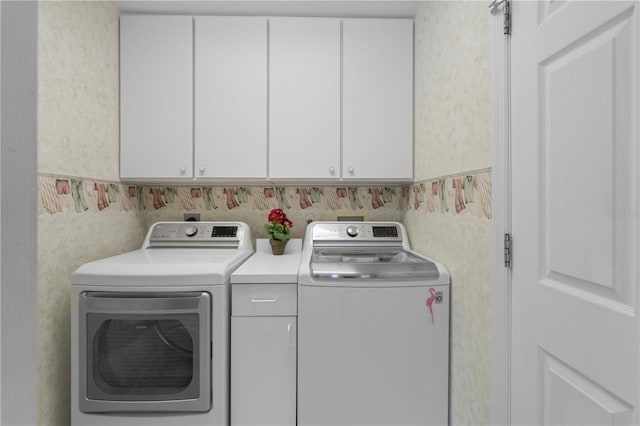 laundry room featuring cabinets and washer and clothes dryer