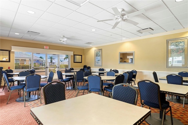 carpeted dining space with ceiling fan and ornamental molding