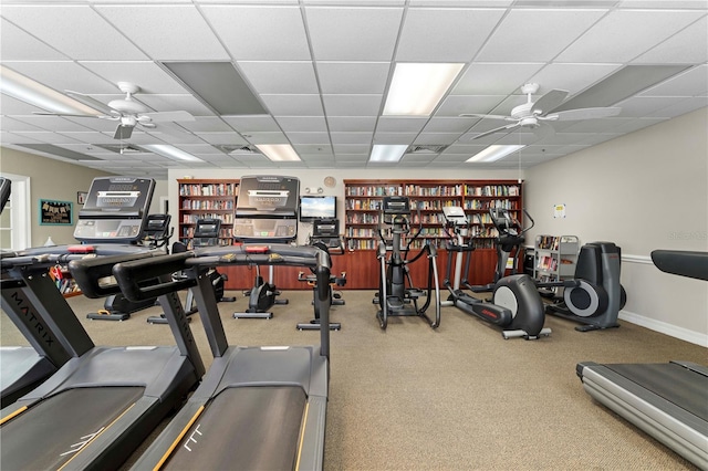 gym with ceiling fan, a drop ceiling, and carpet floors