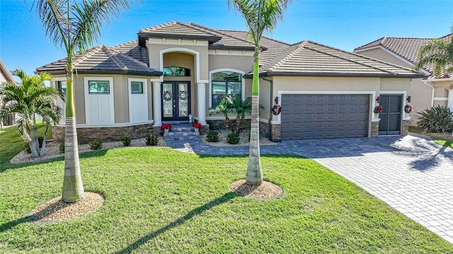 view of front of property featuring french doors, a garage, and a front lawn