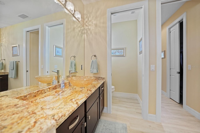 bathroom with hardwood / wood-style floors, vanity, and toilet