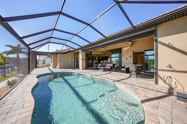 view of pool featuring a patio area, ceiling fan, and glass enclosure