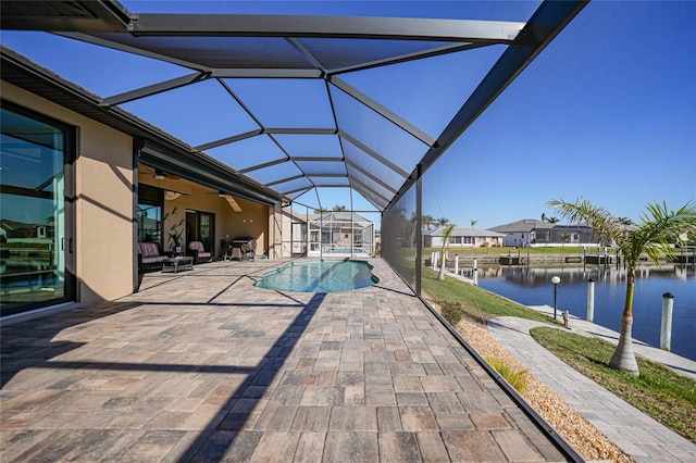 view of pool with a lanai, ceiling fan, a water view, and a patio