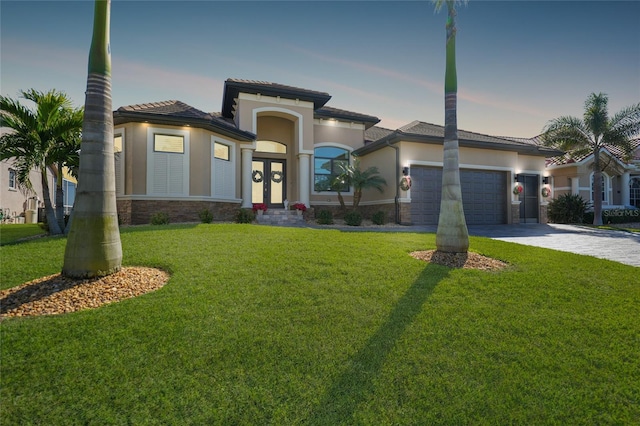 view of front of home featuring a yard, french doors, and a garage