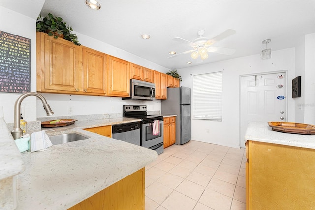 kitchen featuring light stone countertops, stainless steel appliances, ceiling fan, sink, and light tile patterned floors