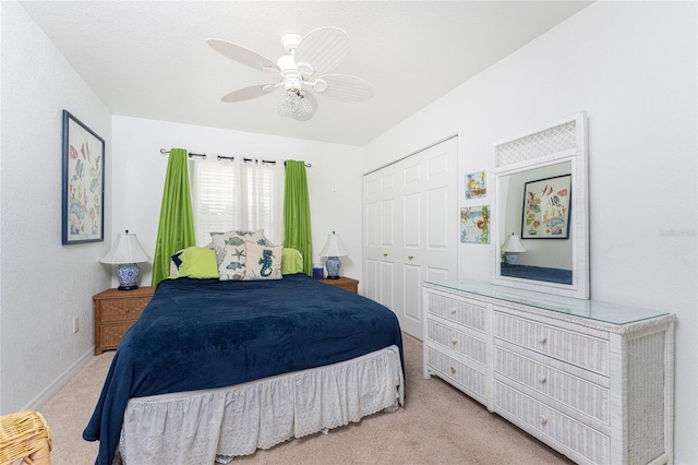 carpeted bedroom featuring ceiling fan and a closet