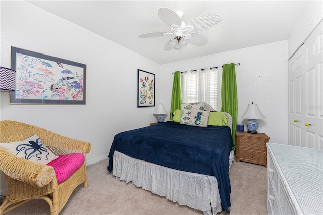 carpeted bedroom with ceiling fan and a closet