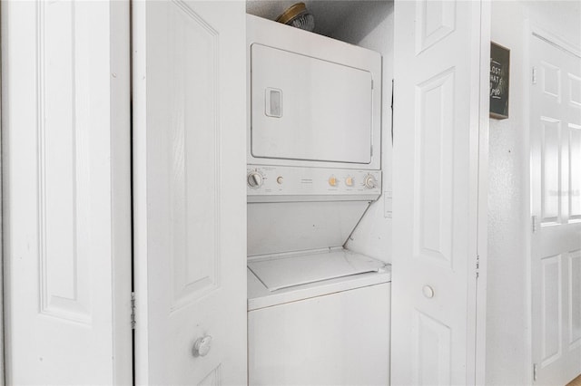 clothes washing area with stacked washer / dryer